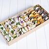 Variety of colourful sushi rolls with fresh ingredients in a takeaway box.