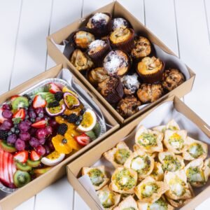Assorted baked goods and fresh fruit in takeaway boxes from The Moody Chef.
