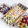 Assorted gourmet sandwiches, desserts, and fresh fruit platter from The Moody Chef.