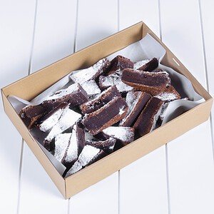 Chocolate brownies in a box with powdered sugar on top.