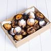 Freshly baked muffins in a cardboard box with powdered sugar on top.