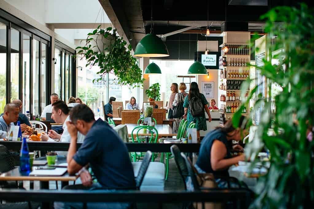 Vibrant cafe scene with customers dining and staff serving at The Moody Chef.